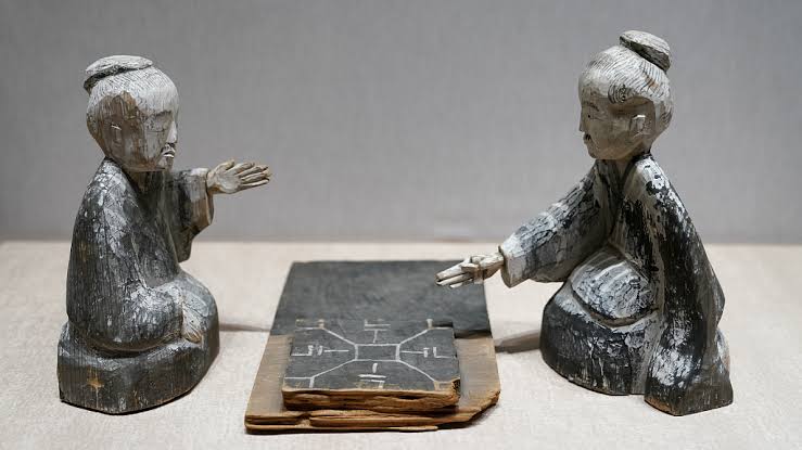 Han dynasty wooden figurines of two liubo players at a game board